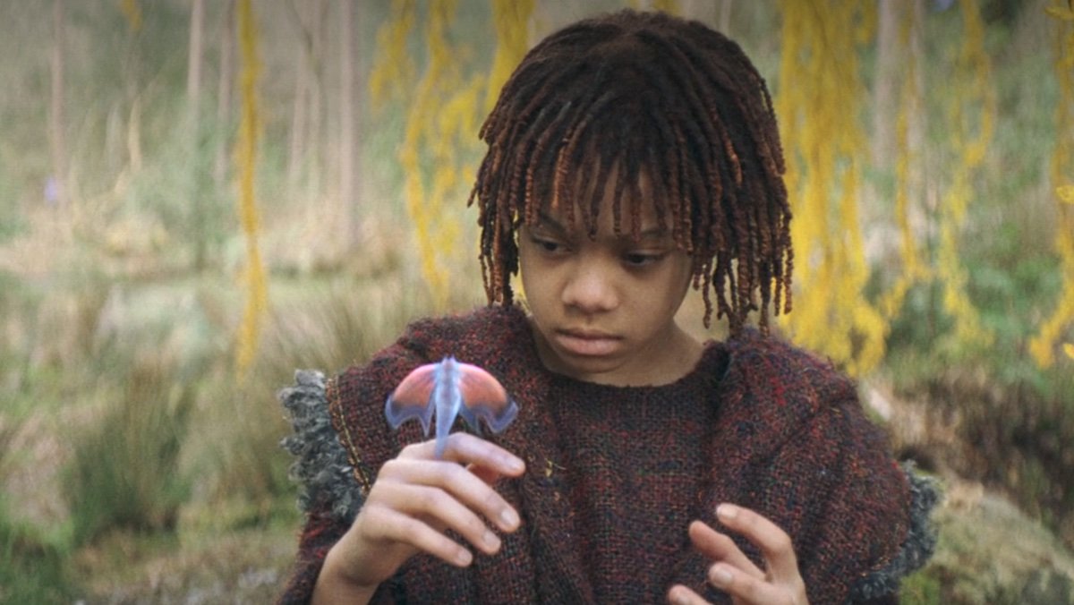 A young girl admires a butterfly on her hand on The Acolyte